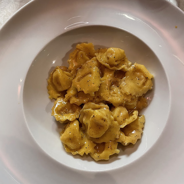 Homemade Tortelli Filled with Pumpkin on Cheese Cream and Ham